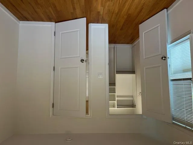 Unfurnished bedroom with wood finished floors and a walk in closet Unfurnished bedroom with wood finished floors and a walk in closet