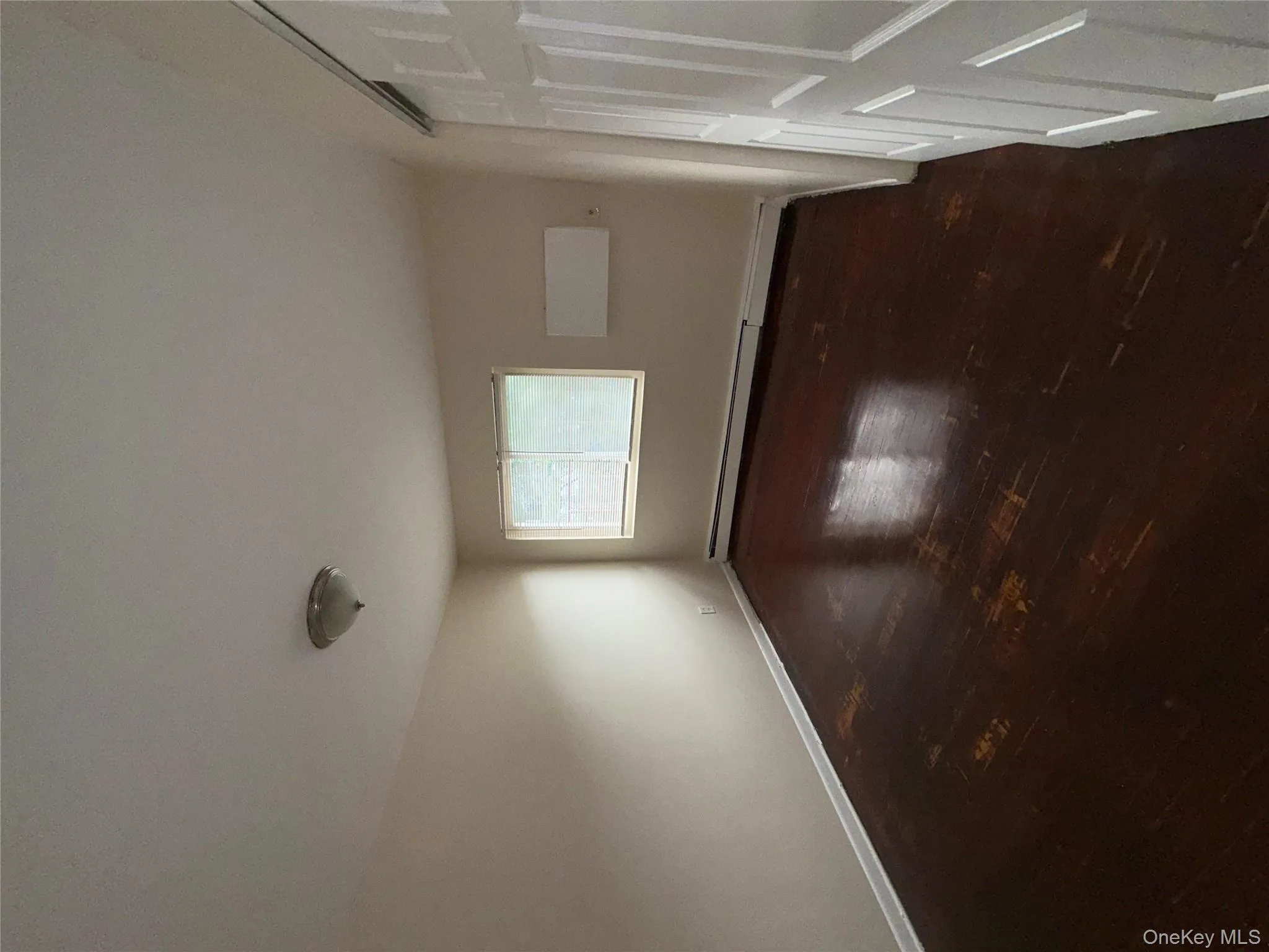 Unfurnished room with dark wood-style flooring and a baseboard heating unit Unfurnished room with dark wood-style flooring and a baseboard heating unit