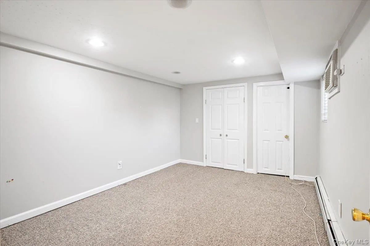Below grade area featuring baseboard heating, carpet, and recessed lighting Below grade area featuring baseboard heating, carpet, and recessed lighting