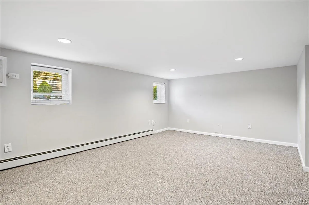 Unfurnished room with baseboard heating, light colored carpet, and recessed lighting Unfurnished room with baseboard heating, light colored carpet, and recessed lighting