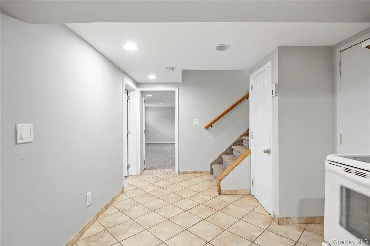 Kitchen featuring white electric range, recessed lighting, and light tile patterned floors Kitchen featuring white electric range, recessed lighting, and light tile patterned floors
