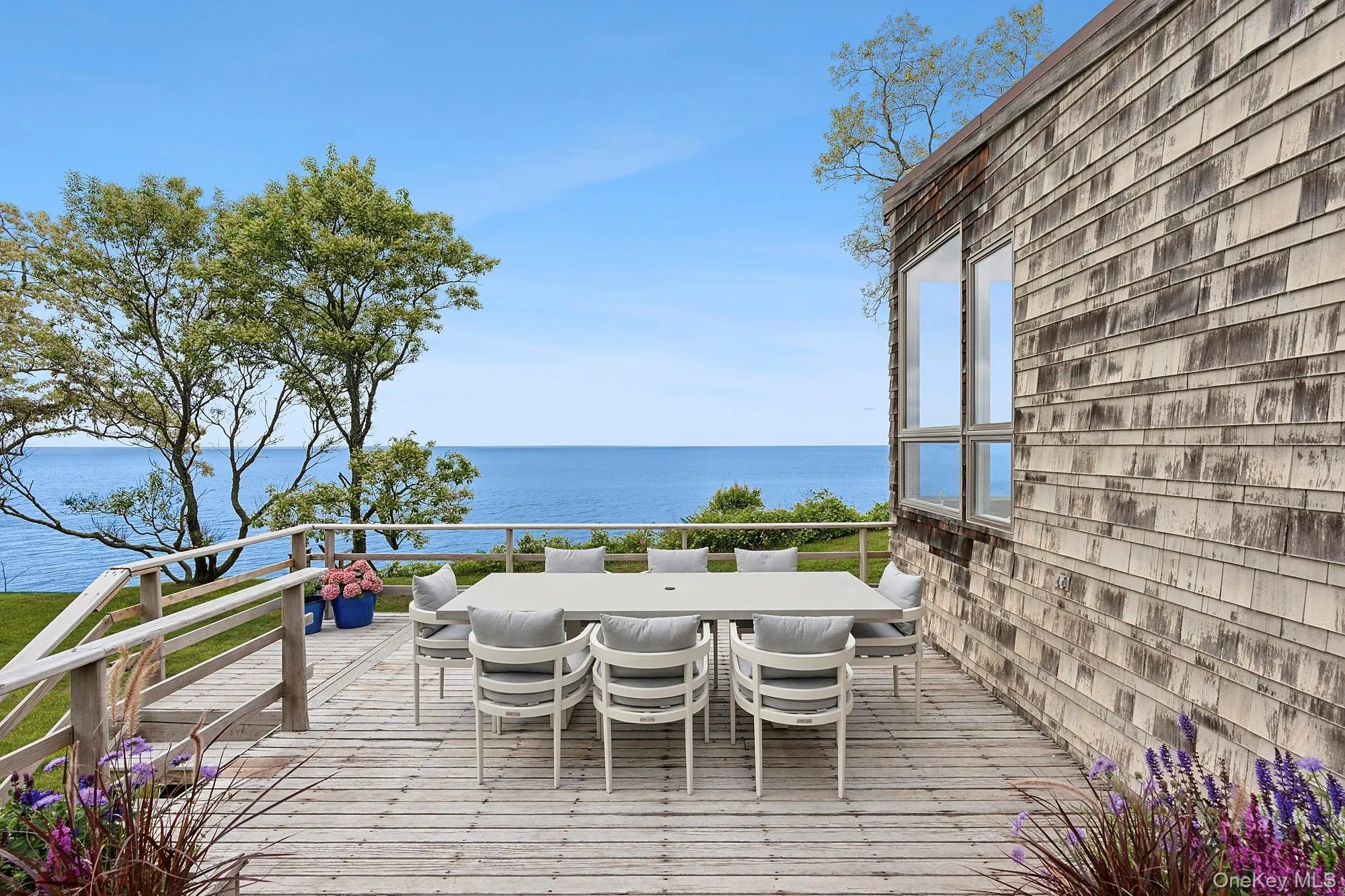 Wooden deck featuring a water view and outdoor dining area Wooden deck featuring a water view and outdoor dining area