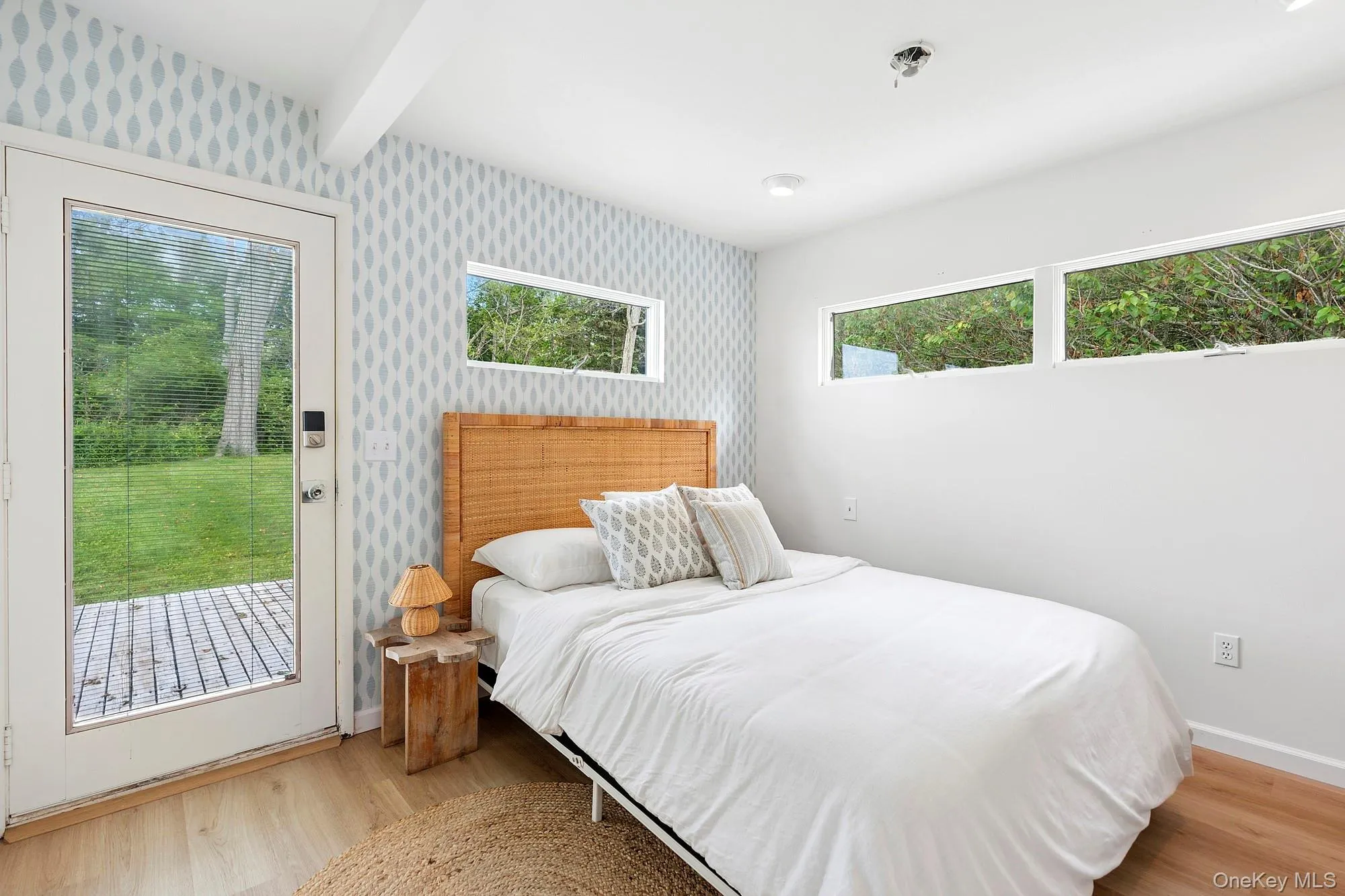 Bedroom featuring light wood-style floors, beamed ceiling, and access to outside Bedroom featuring light wood-style floors, beamed ceiling, and access to outside