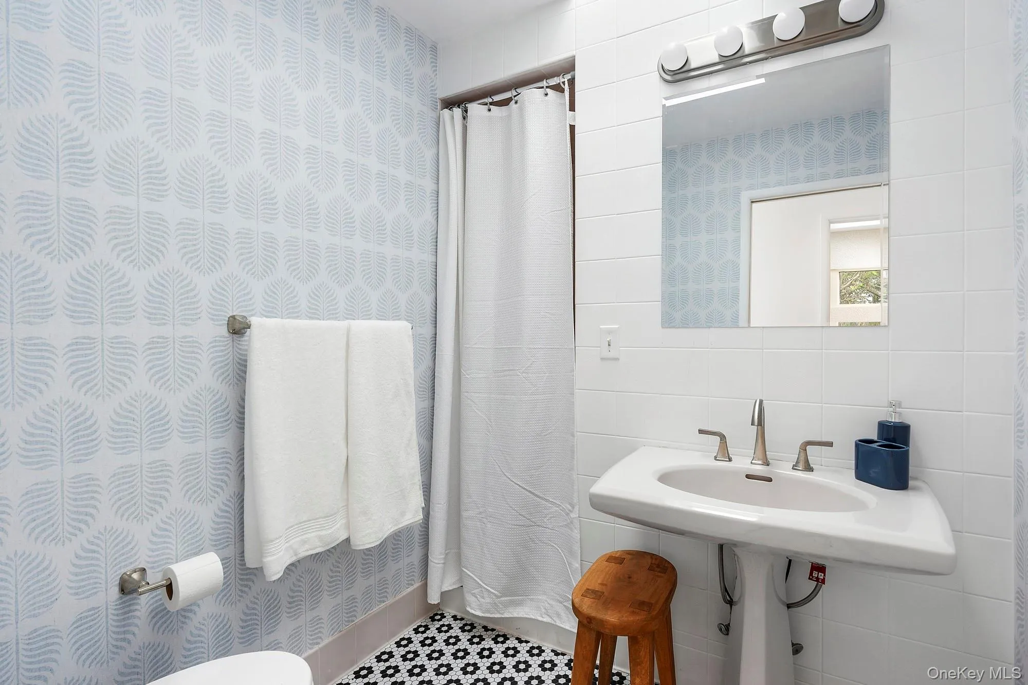 Bathroom featuring tile walls and curtained shower Bathroom featuring tile walls and curtained shower