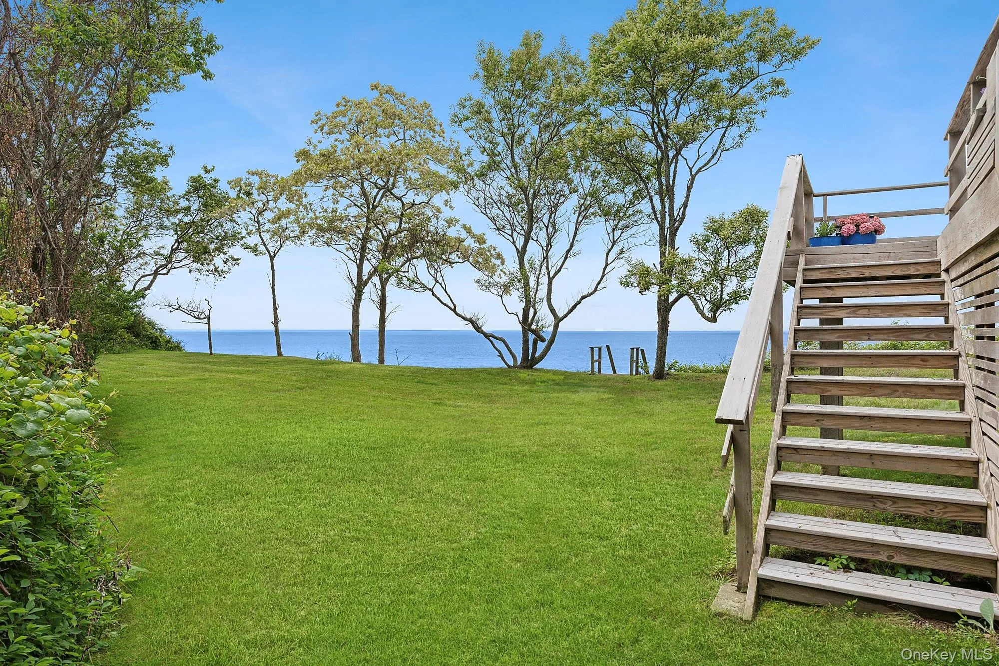 View of grassy yard with stairway and a water view View of grassy yard with stairway and a water view