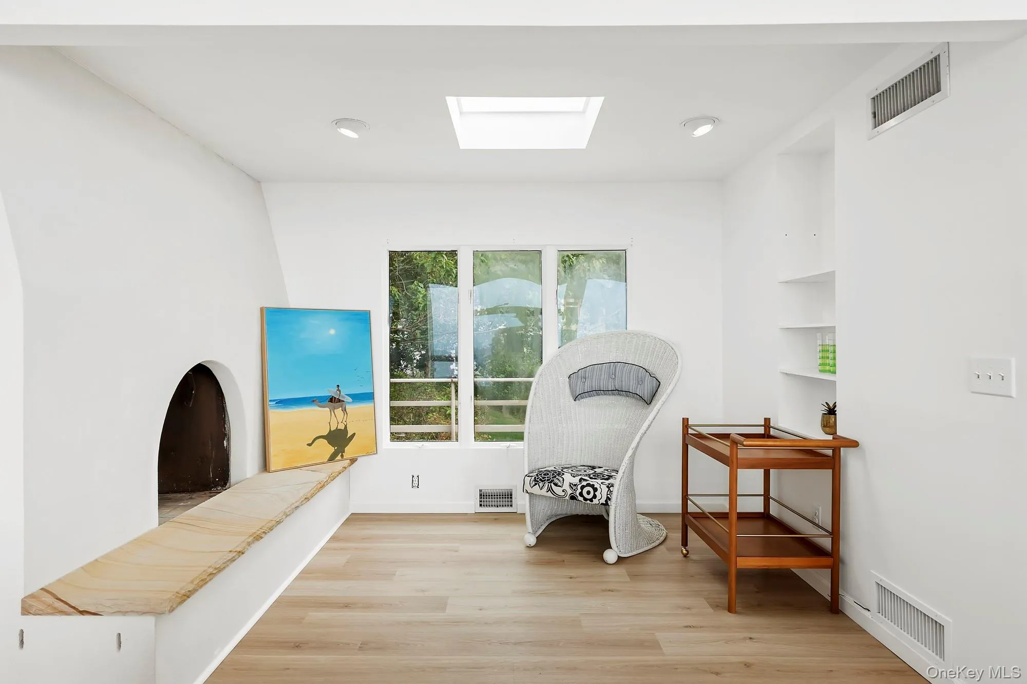 Living area featuring a skylight and light wood finished floors Living area featuring a skylight and light wood finished floors