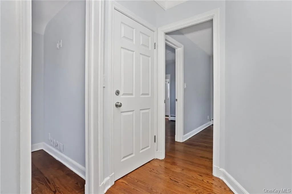 Hallway featuring dark wood-style flooring and baseboards Hallway featuring dark wood-style flooring and baseboards