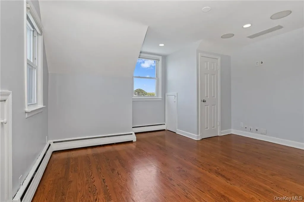 Spare room with baseboard heating, dark wood finished floors, a baseboard radiator, vaulted ceiling, and recessed lighting Spare room with baseboard heating, dark wood finished floors, a baseboard radiator, vaulted ceiling, and recessed lighting
