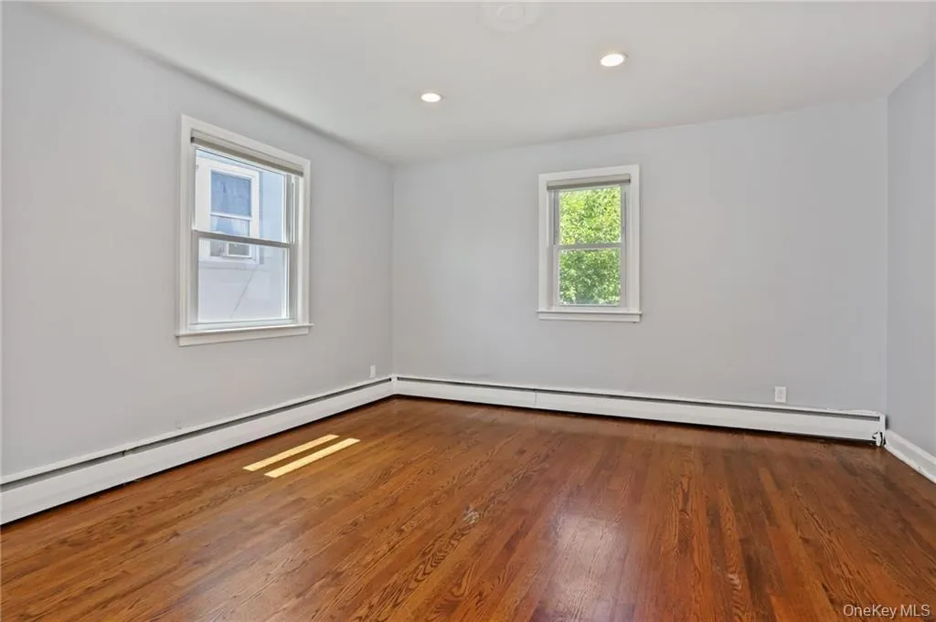 Spare room with baseboard heating, wood finished floors, and recessed lighting Spare room with baseboard heating, wood finished floors, and recessed lighting