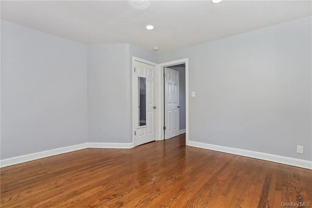 Unfurnished room with dark wood-style flooring and recessed lighting Unfurnished room with dark wood-style flooring and recessed lighting
