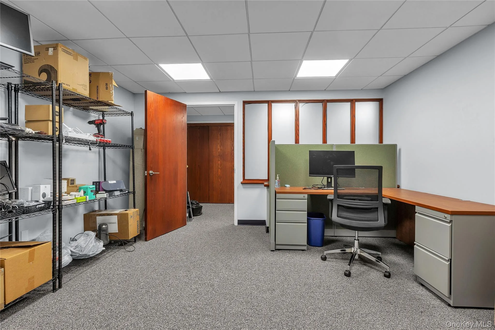 Office with light carpet and a paneled ceiling Office with light carpet and a paneled ceiling