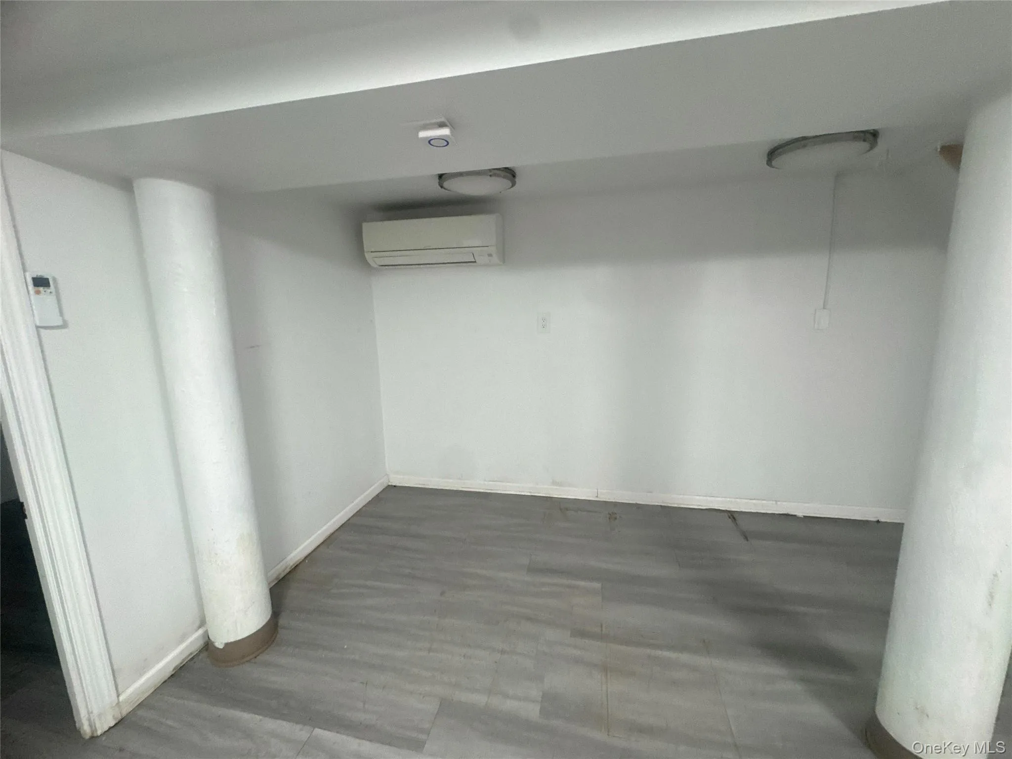 Finished below grade area featuring a wall unit AC and baseboards Finished below grade area featuring a wall unit AC and baseboards