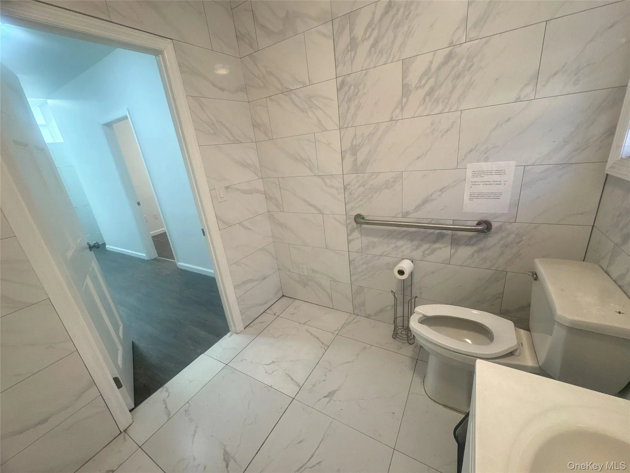 Bathroom featuring marble finish floors, tile walls, and vanity Bathroom featuring marble finish floors, tile walls, and vanity