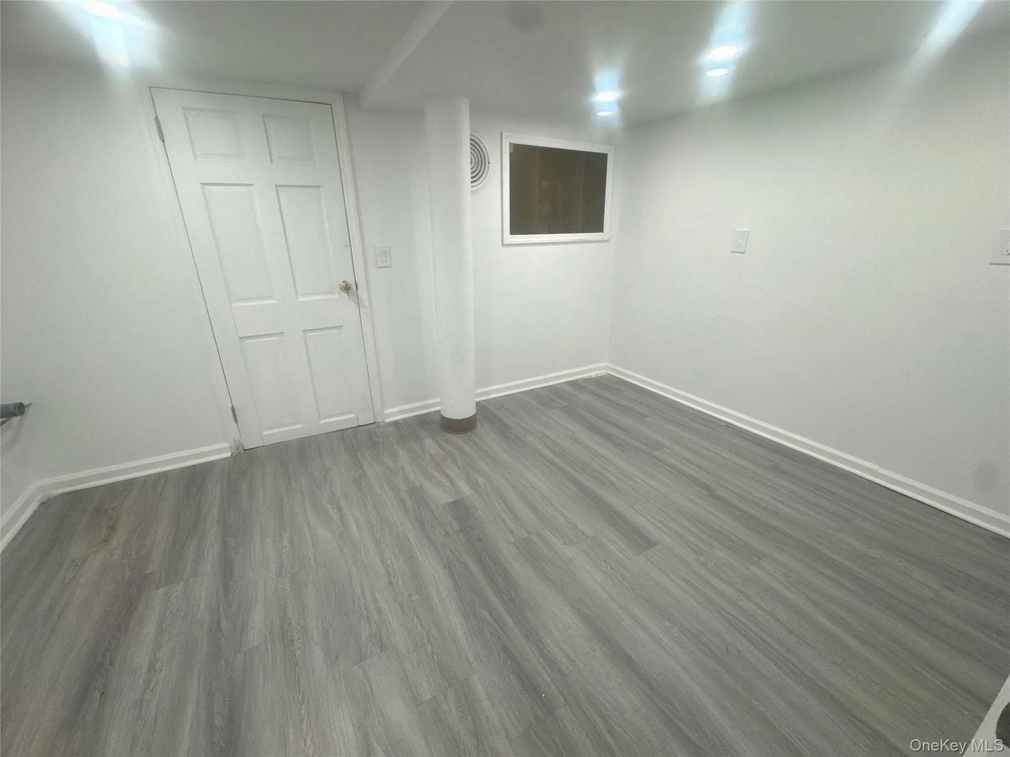 Finished below grade area featuring baseboards and dark wood-style flooring Finished below grade area featuring baseboards and dark wood-style flooring