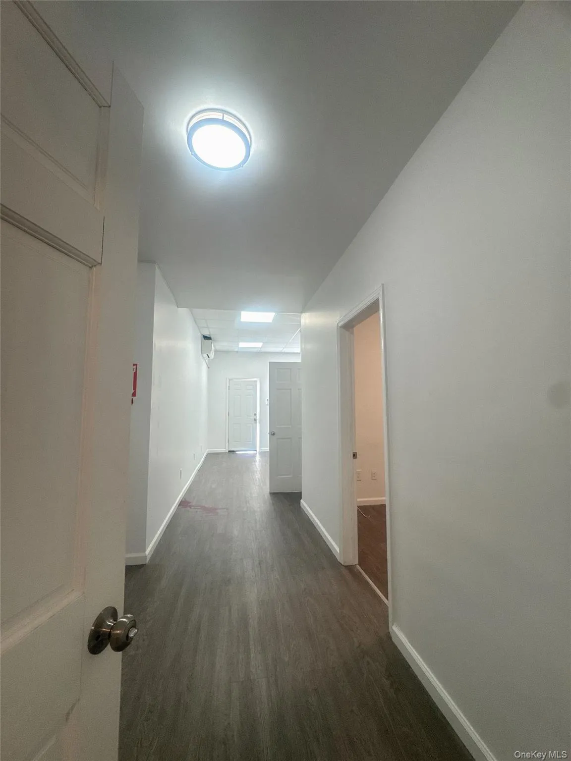 Hall featuring dark wood-style floors and baseboards Hall featuring dark wood-style floors and baseboards