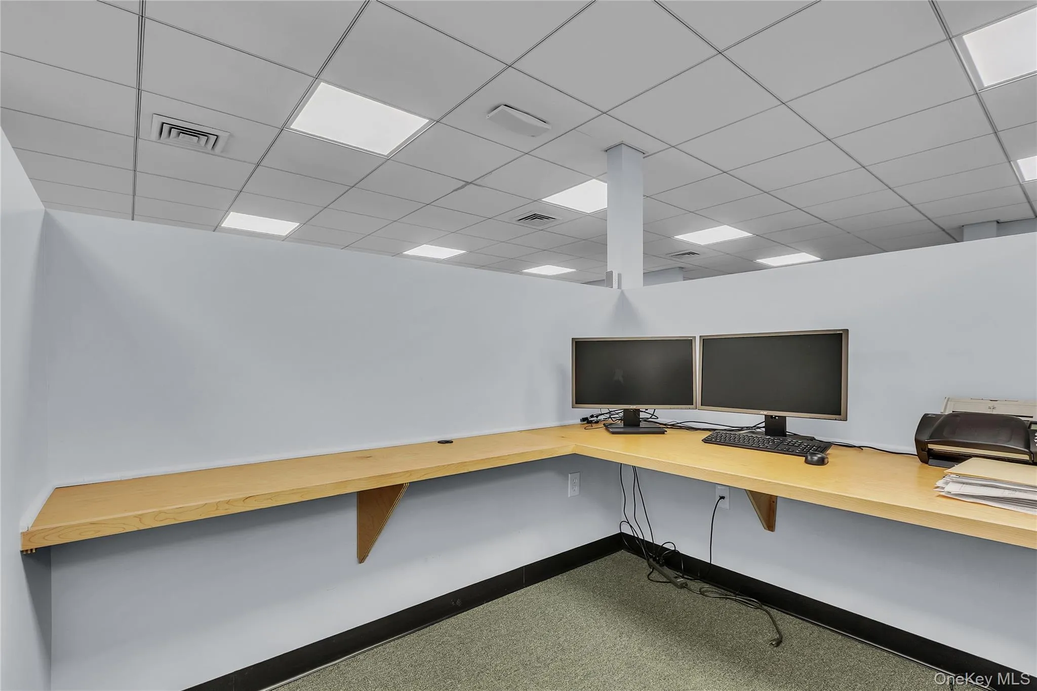 Unfurnished office with built in desk and a drop ceiling Unfurnished office with built in desk and a drop ceiling