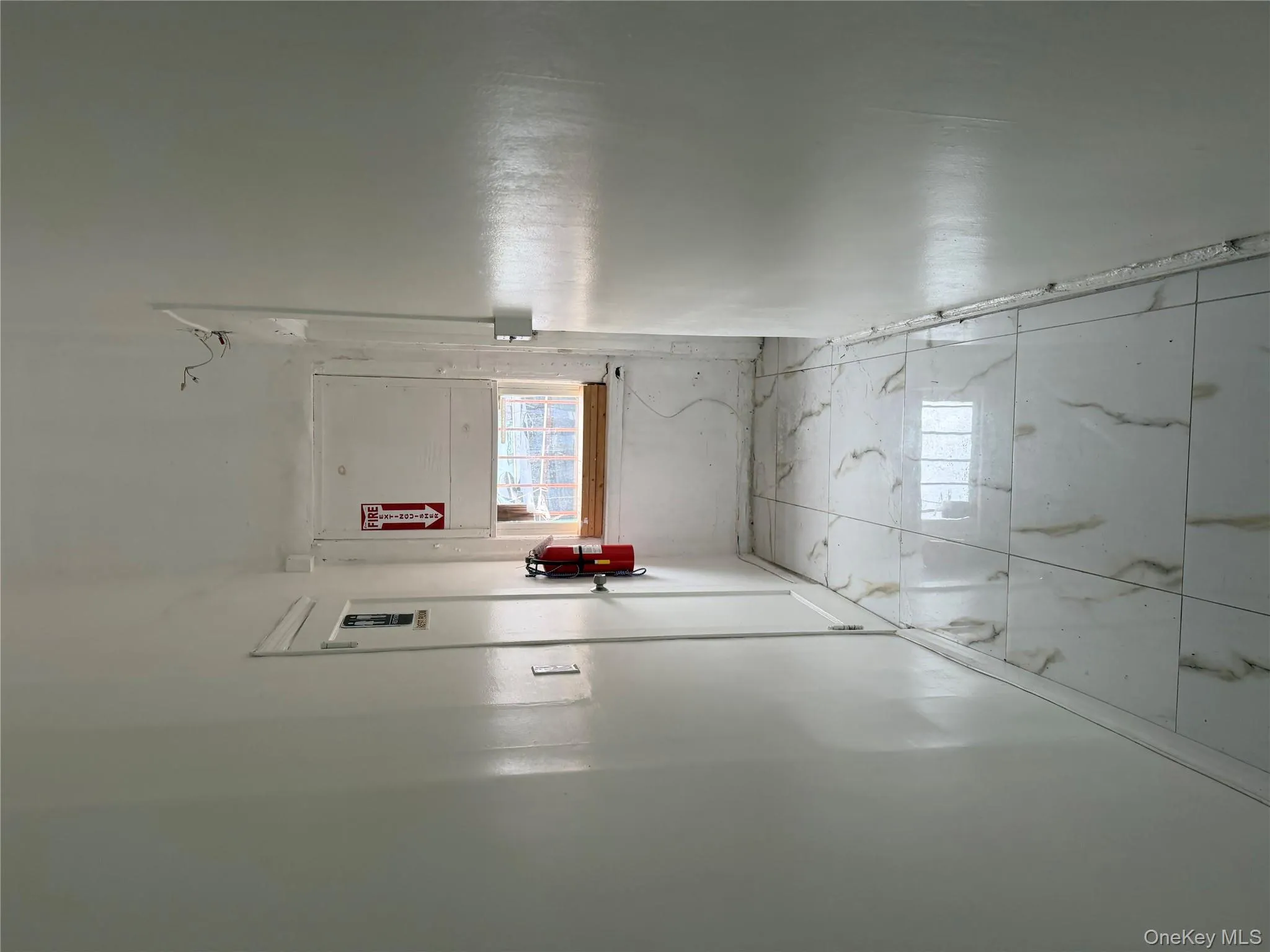 Hallway featuring light marble finish floors and baseboards Hallway featuring light marble finish floors and baseboards