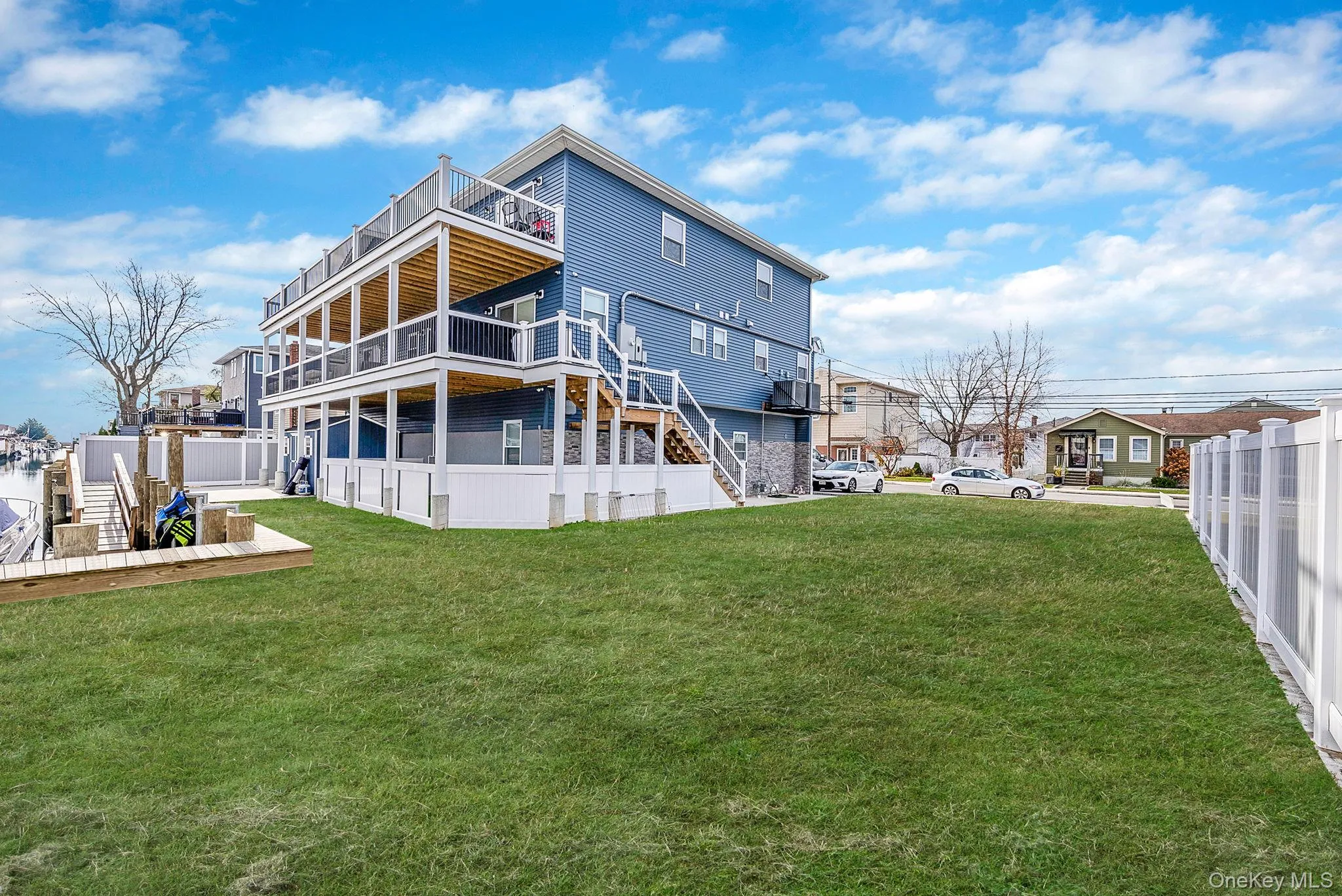 Back of property featuring stairway, a wooden deck, and a balcony Back of property featuring stairway, a wooden deck, and a balcony