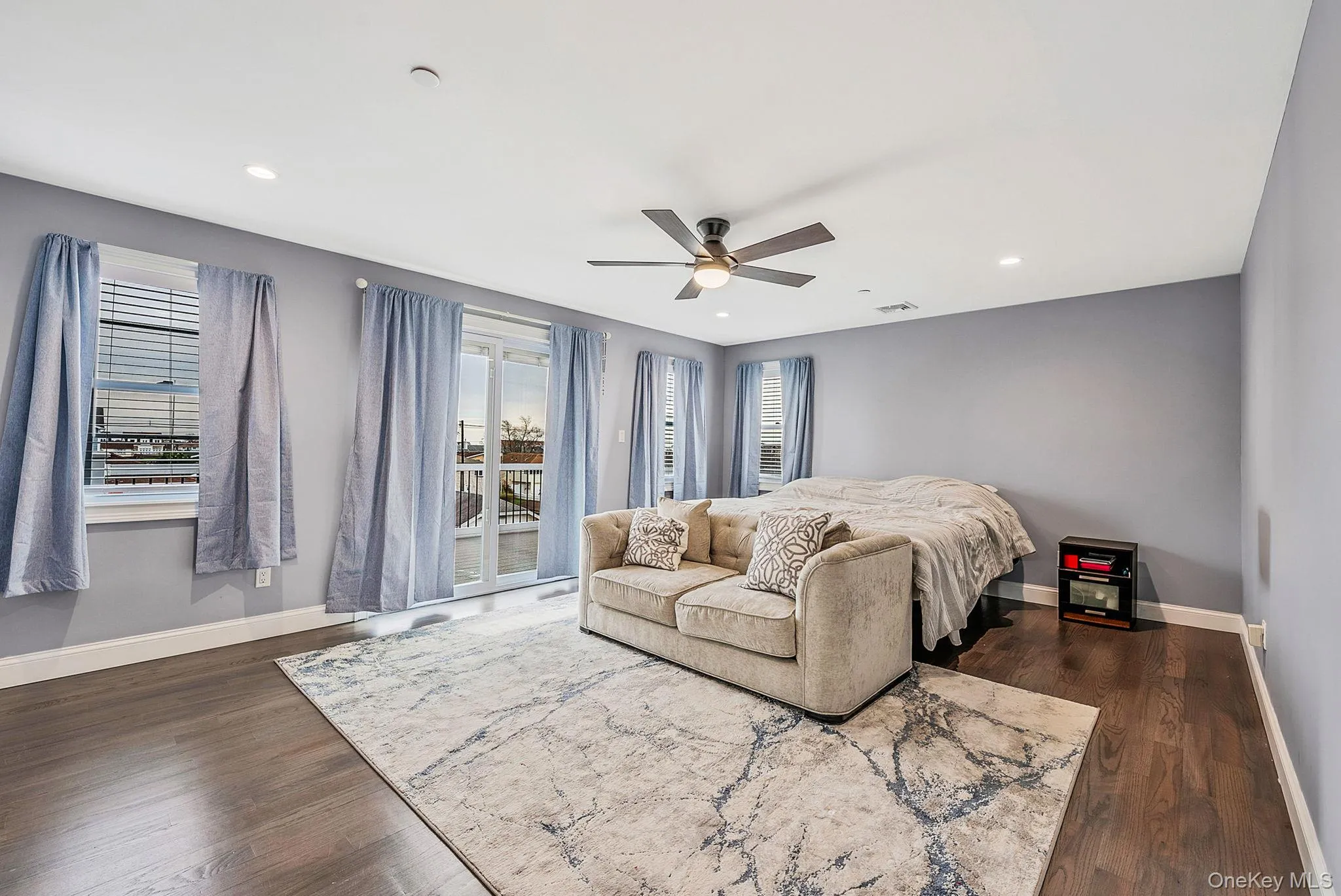 Bedroom featuring dark wood-type flooring, a ceiling fan, access to exterior, and recessed lighting Bedroom featuring dark wood-type flooring, a ceiling fan, access to exterior, and recessed lighting