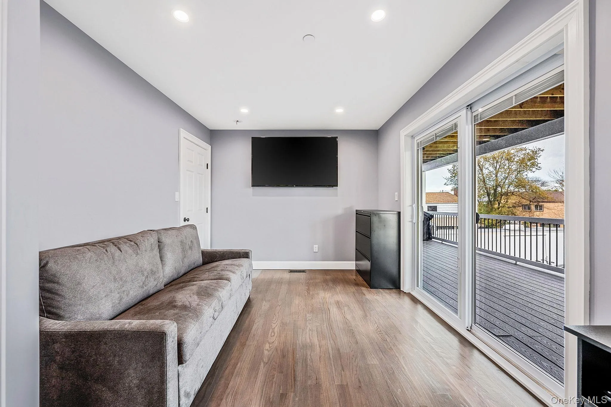 Living area with recessed lighting and wood finished floors Living area with recessed lighting and wood finished floors
