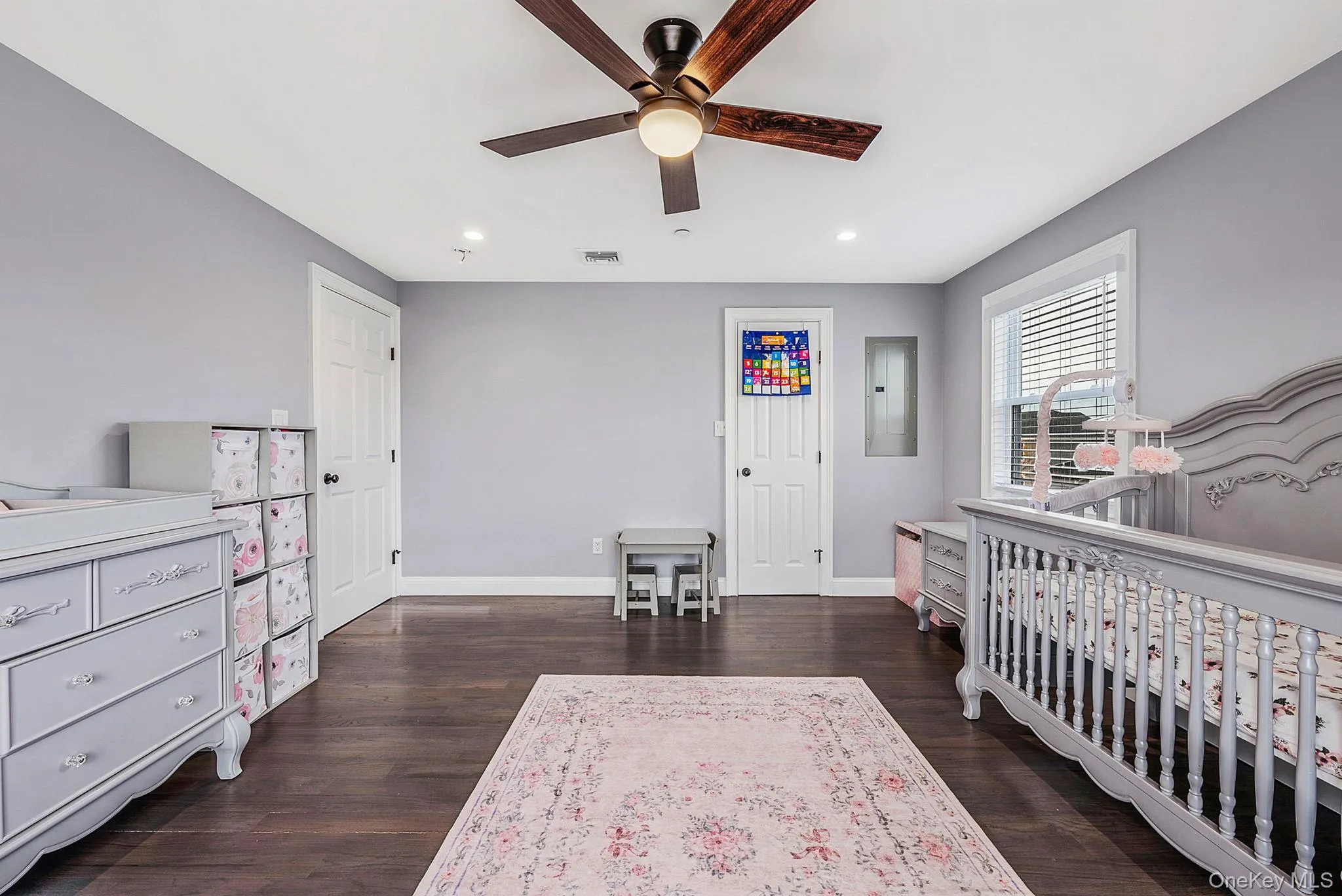 Bedroom with a nursery area, dark wood finished floors, recessed lighting, a ceiling fan, and electric panel Bedroom with a nursery area, dark wood finished floors, recessed lighting, a ceiling fan, and electric panel