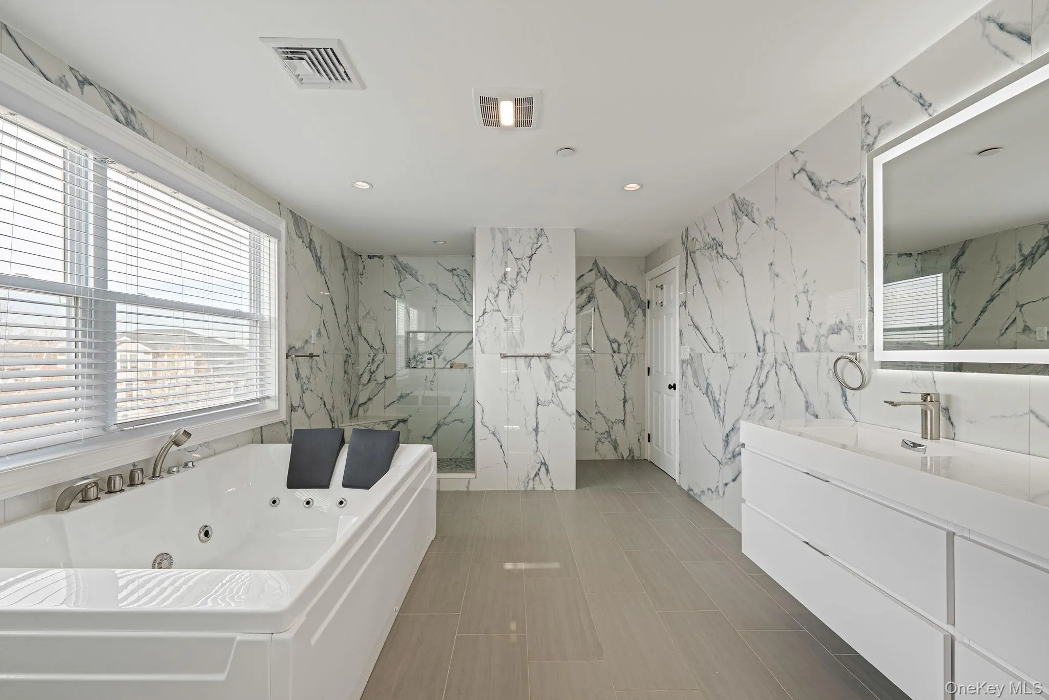 Full bath featuring a tub with jets, vanity, a marble finish shower, and recessed lighting Full bath featuring a tub with jets, vanity, a marble finish shower, and recessed lighting
