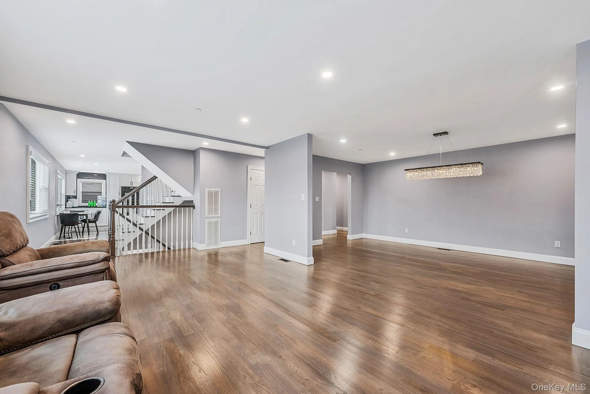 Unfurnished living room featuring recessed lighting, wood finished floors, and stairway Unfurnished living room featuring recessed lighting, wood finished floors, and stairway