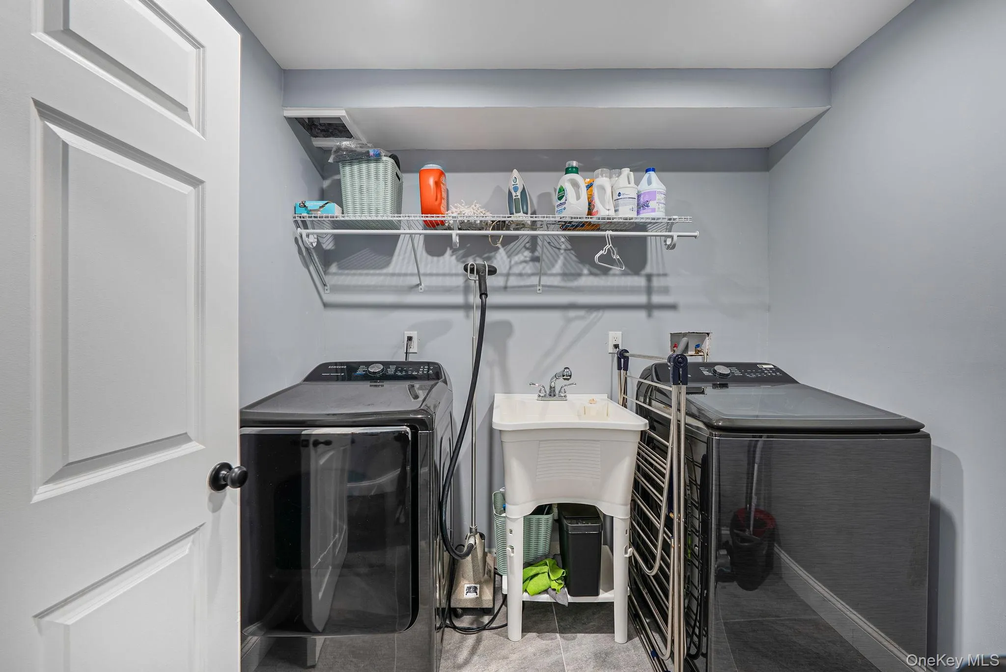 Washroom with washing machine and clothes dryer and light tile patterned flooring Washroom with washing machine and clothes dryer and light tile patterned flooring