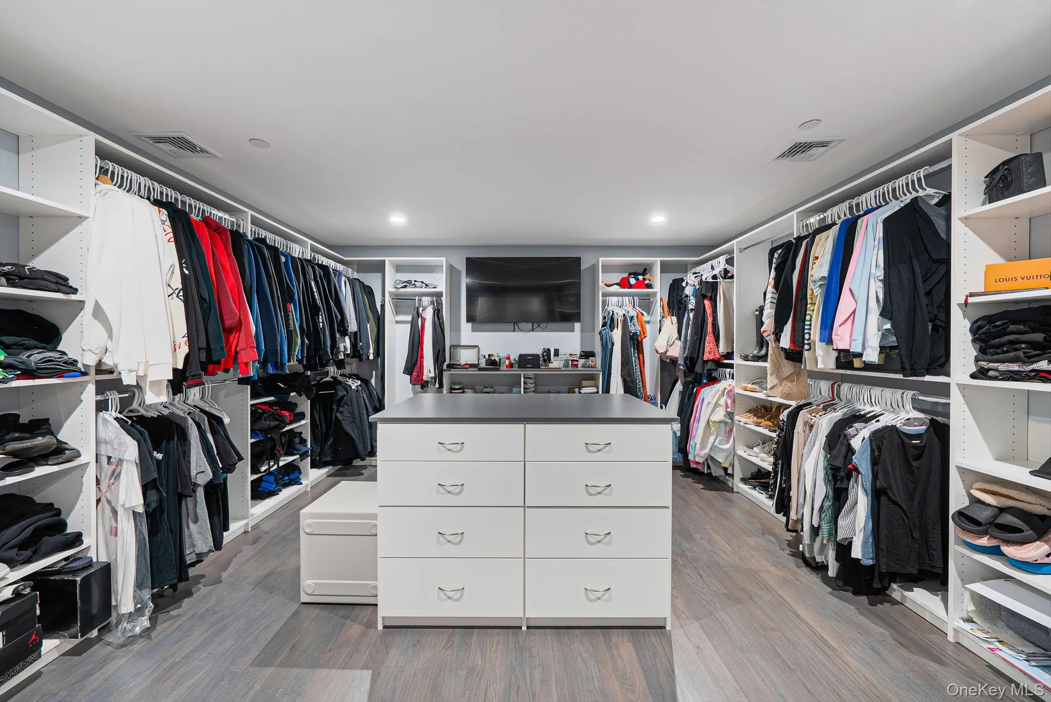 Walk in closet with light wood finished floors Walk in closet with light wood finished floors