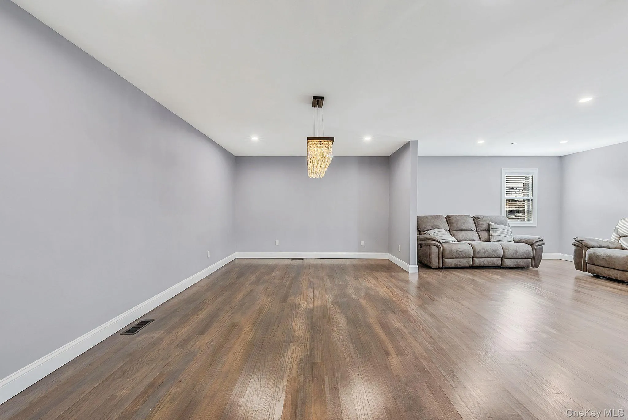 Unfurnished living room with dark wood-style floors and recessed lighting Unfurnished living room with dark wood-style floors and recessed lighting