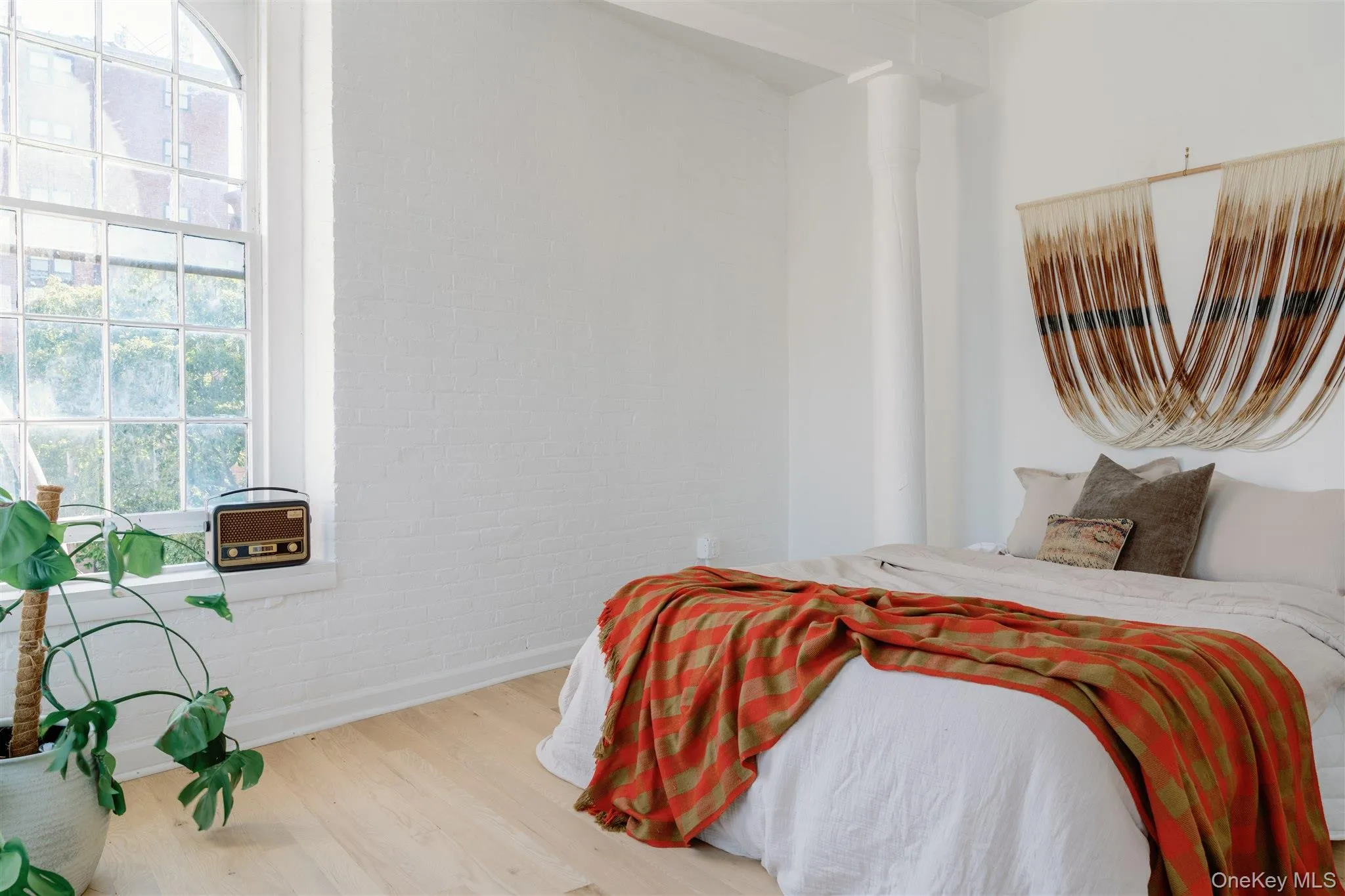Bedroom featuring wood finished floors and brick wall Bedroom featuring wood finished floors and brick wall