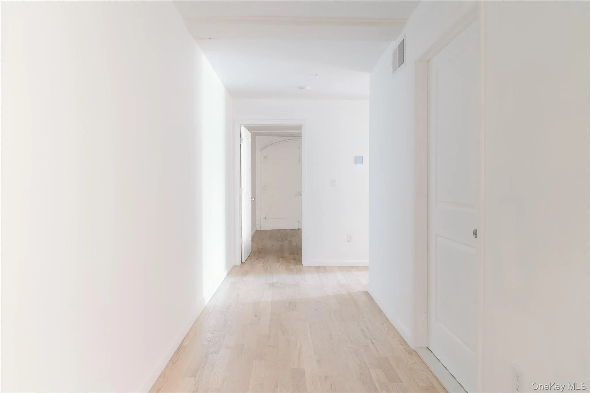 Hallway with light wood-type flooring and baseboards Hallway with light wood-type flooring and baseboards
