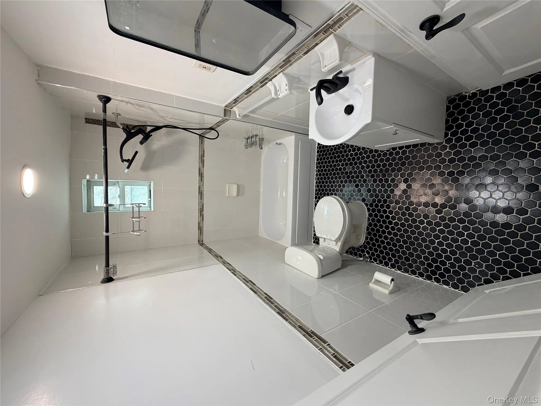 Full bathroom featuring vanity, tile walls, bathtub / shower combination, and dark tile patterned flooring Full bathroom featuring vanity, tile walls, bathtub / shower combination, and dark tile patterned flooring