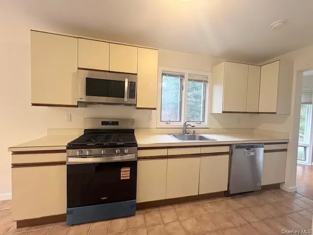 Kitchen with appliances with stainless steel finishes, light countertops Kitchen with appliances with stainless steel finishes, light countertops