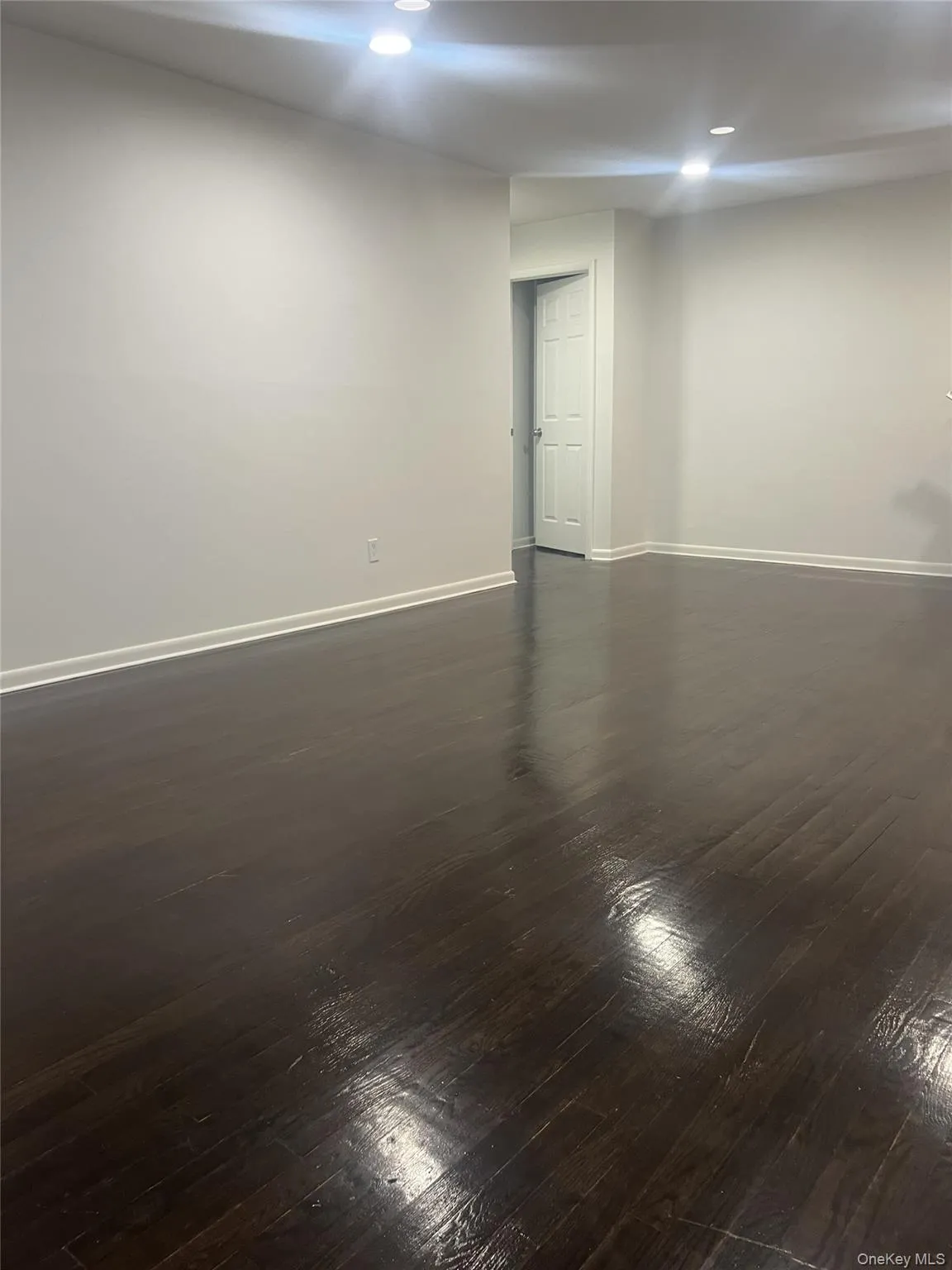 Living room featuring dark wood-style floors and recessed lighting Living room featuring dark wood-style floors and recessed lighting