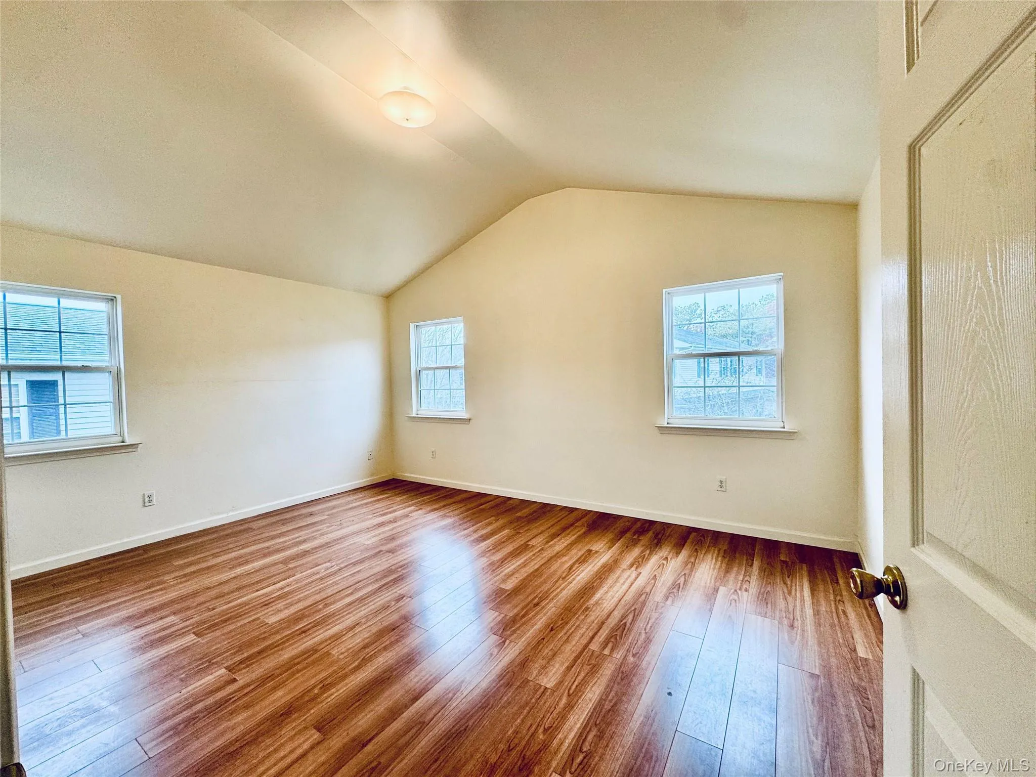 style flooring, lofted ceiling, and plenty of natural lightPrimary Bedroom with high ceilings and natural light style flooring, lofted ceiling, and plenty of natural lightPrimary Bedroom with high ceilings and natural light