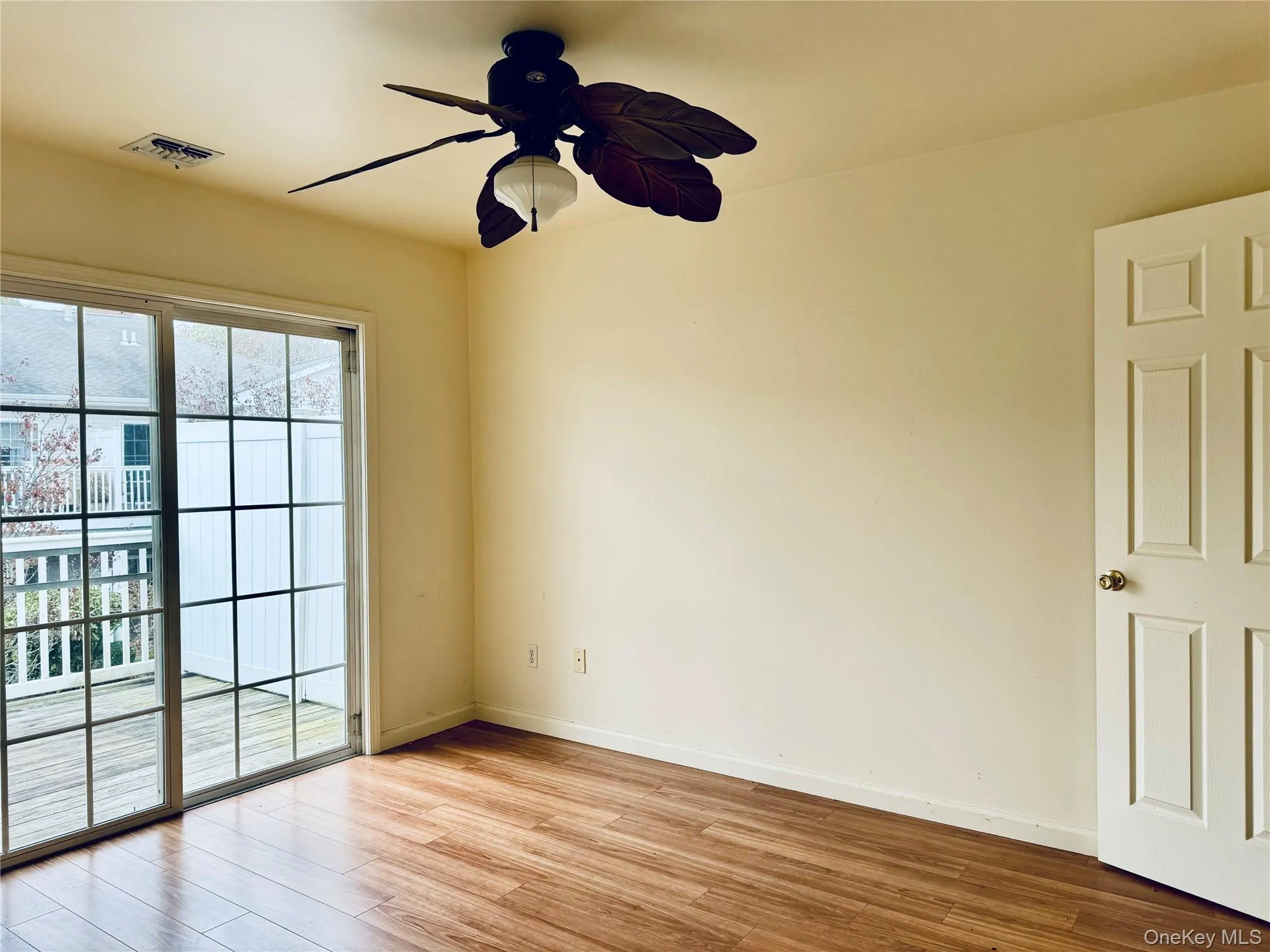 Guest room featuring wood look finished floors and ceiling fan and deck Guest room featuring wood look finished floors and ceiling fan and deck