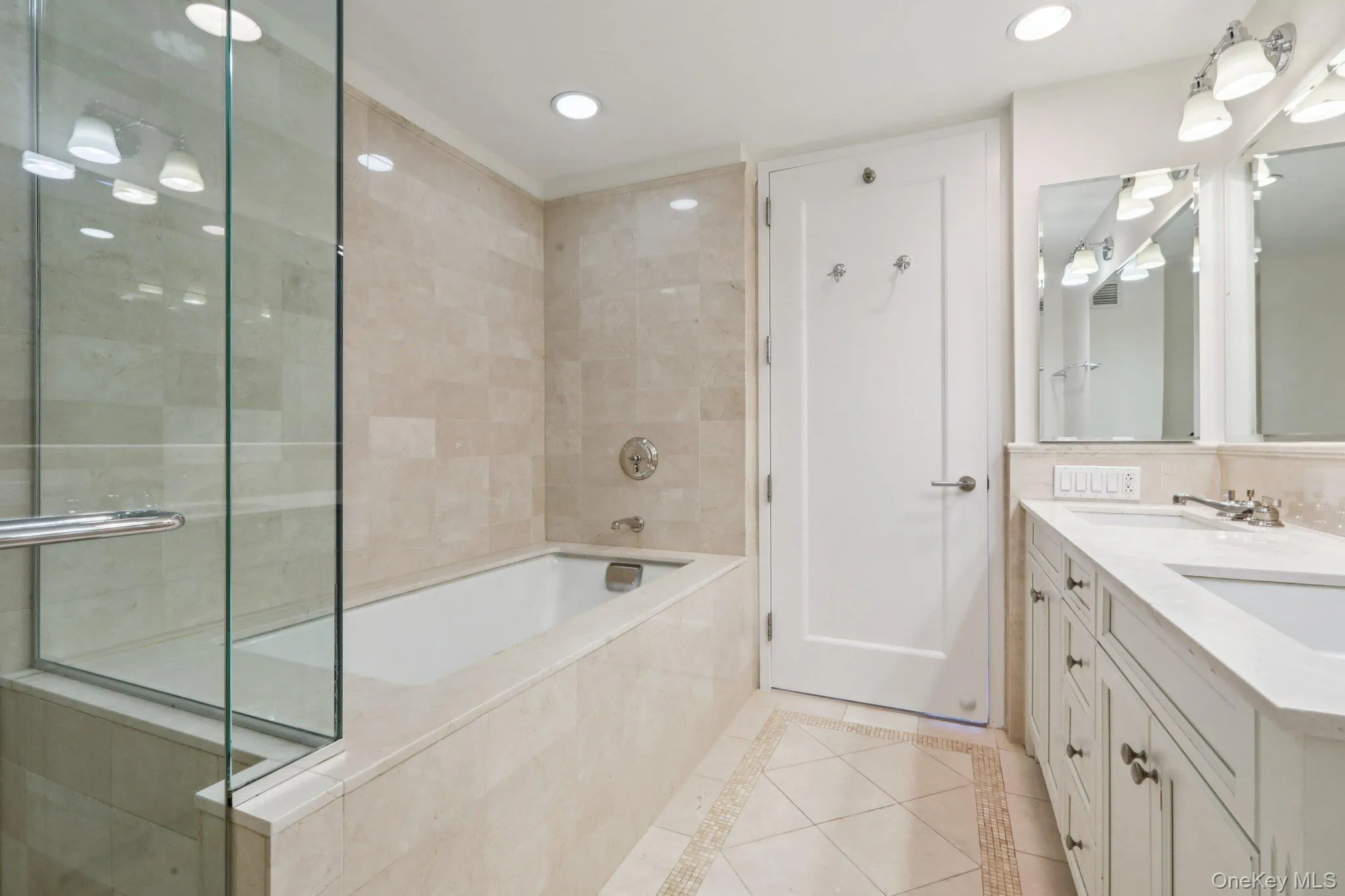 Full bathroom with inlaid floor details, double vanity, a bath, recessed lighting, and a shower stall Full bathroom with inlaid floor details, double vanity, a bath, recessed lighting, and a shower stall