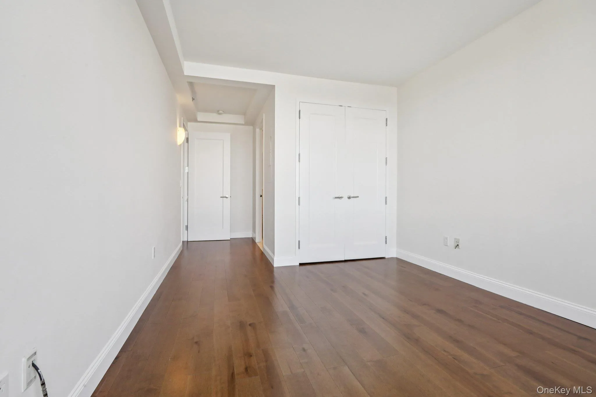 Unfurnished bedroom with dark wood finished floors and a closet Unfurnished bedroom with dark wood finished floors and a closet