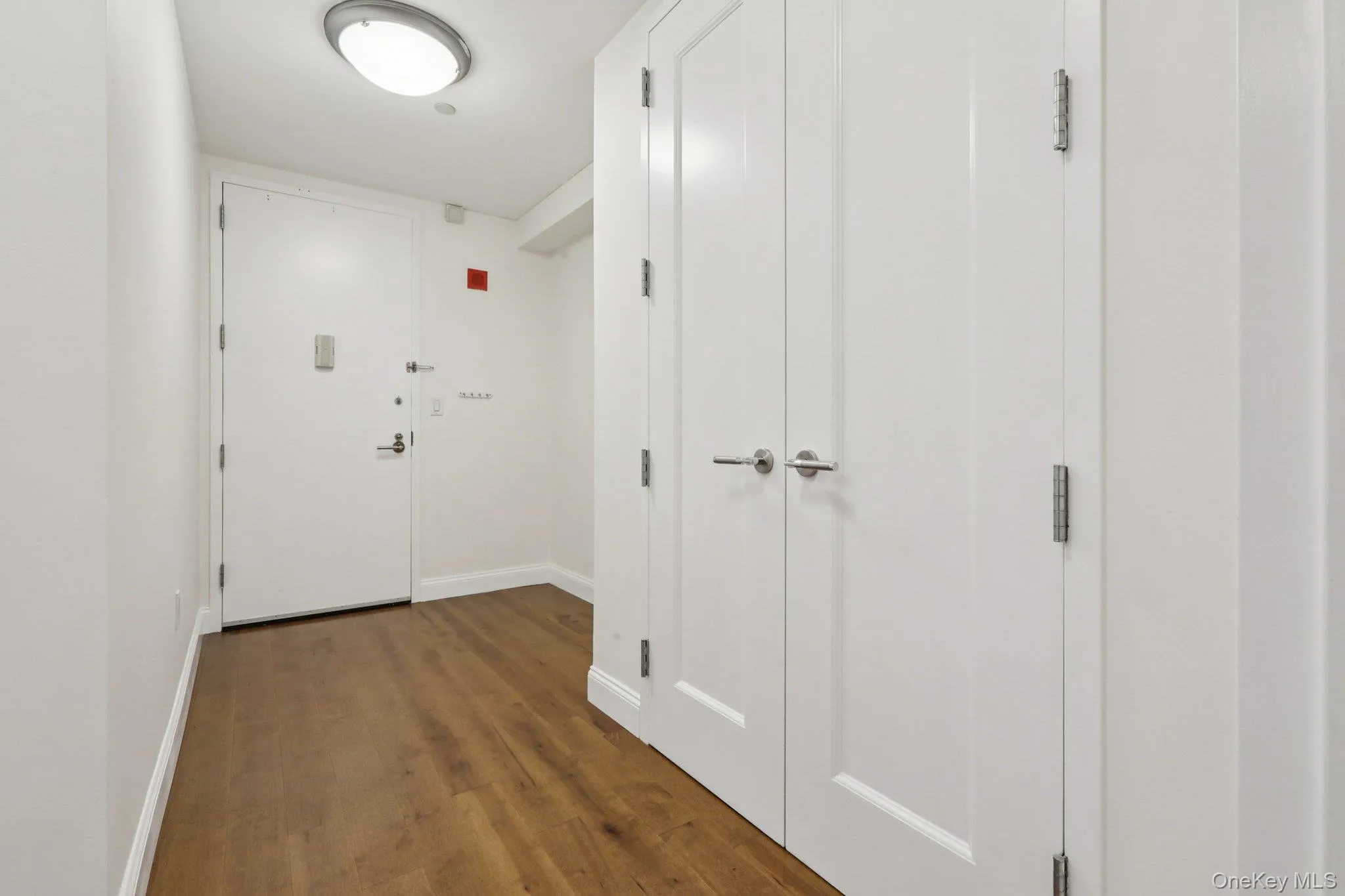 Hallway with baseboards and dark wood finished floors Hallway with baseboards and dark wood finished floors