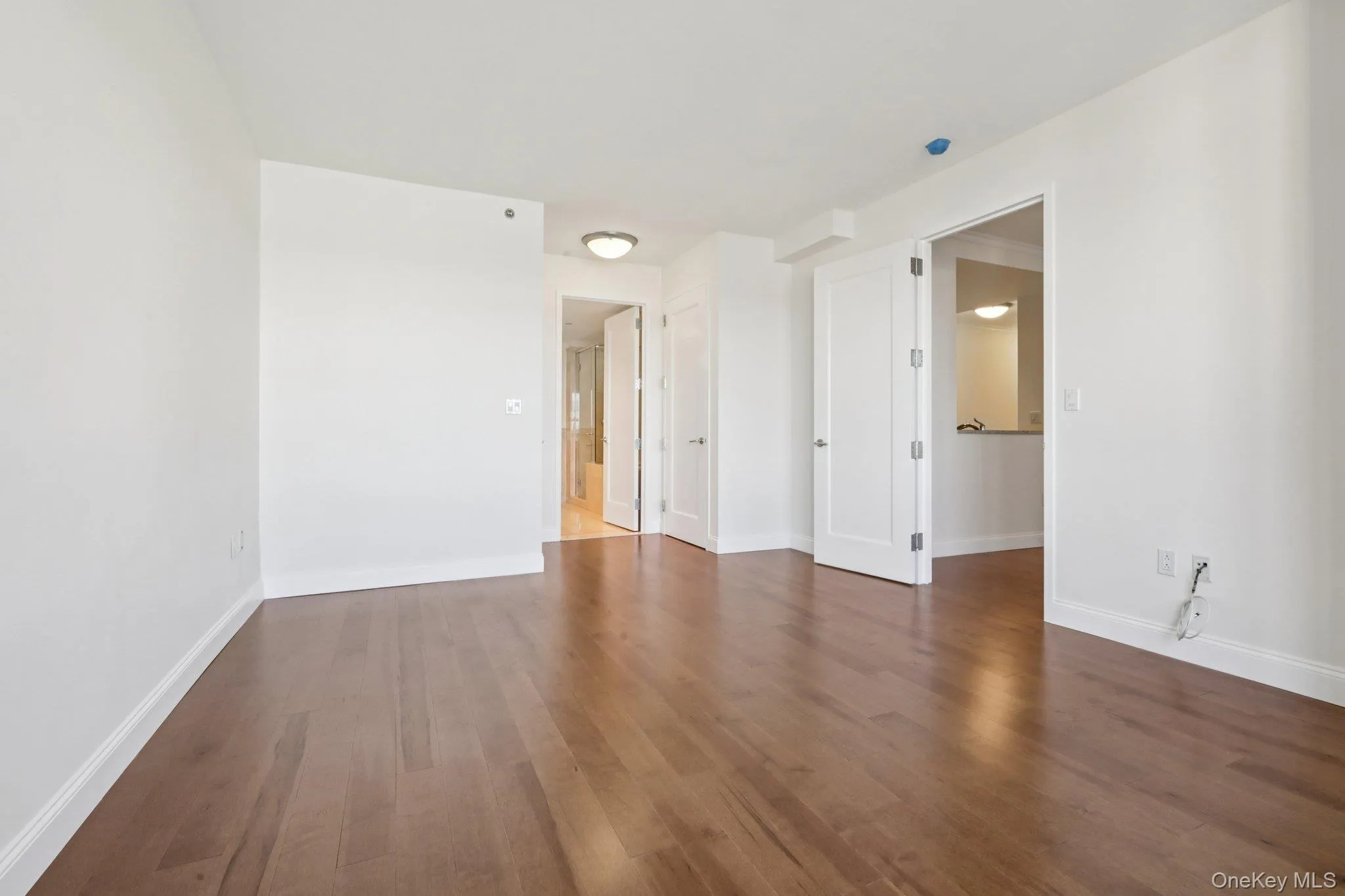 Unfurnished room with dark wood finished floors and baseboards Unfurnished room with dark wood finished floors and baseboards