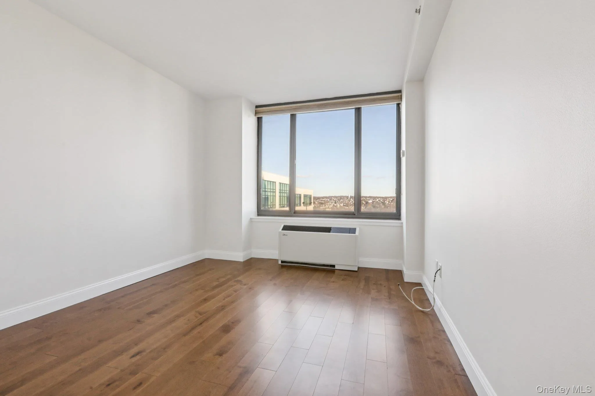 Unfurnished room with wood finished floors and radiator Unfurnished room with wood finished floors and radiator