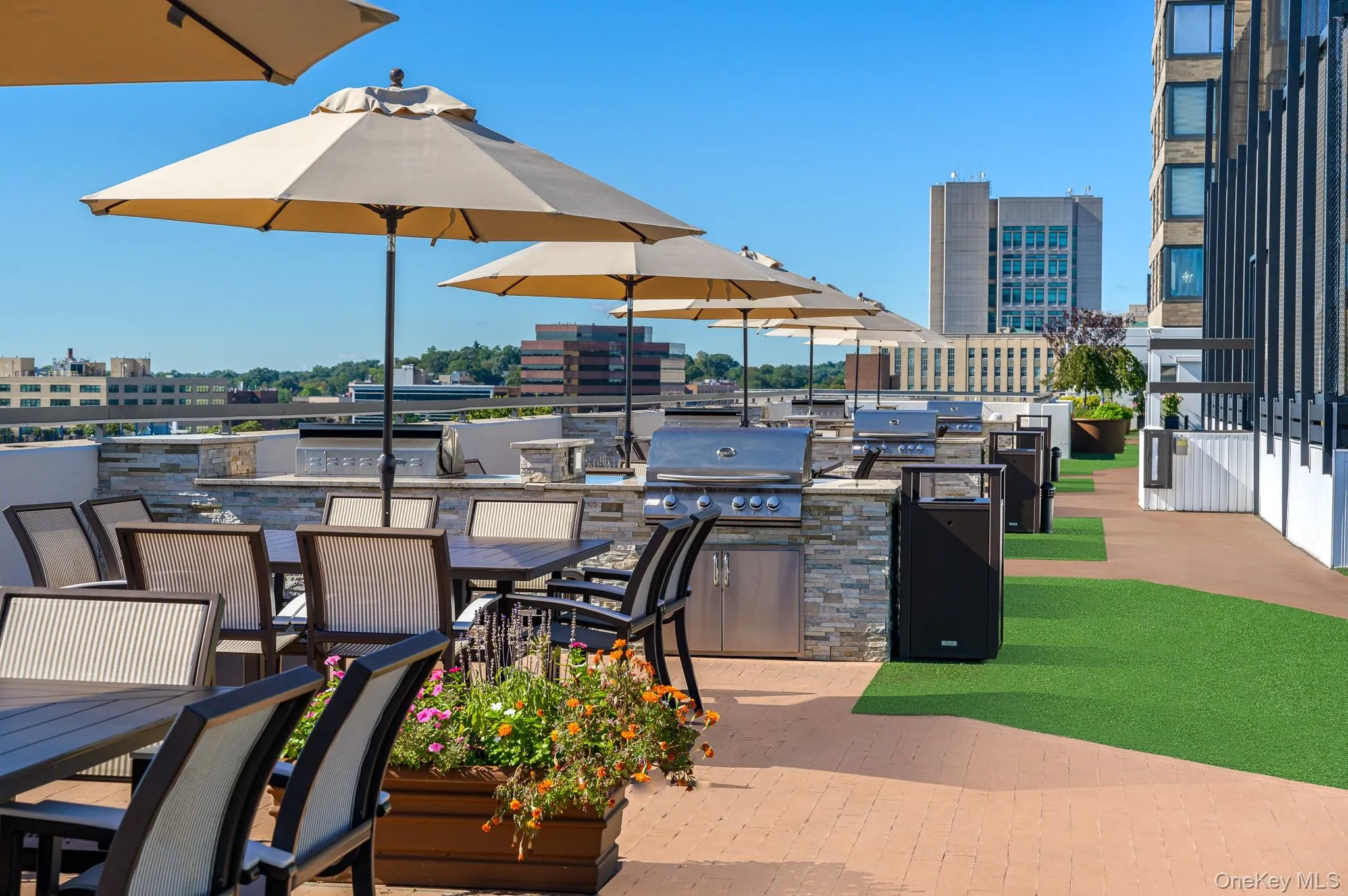 View of patio featuring exterior kitchen, outdoor dining space, and a view of city View of patio featuring exterior kitchen, outdoor dining space, and a view of city