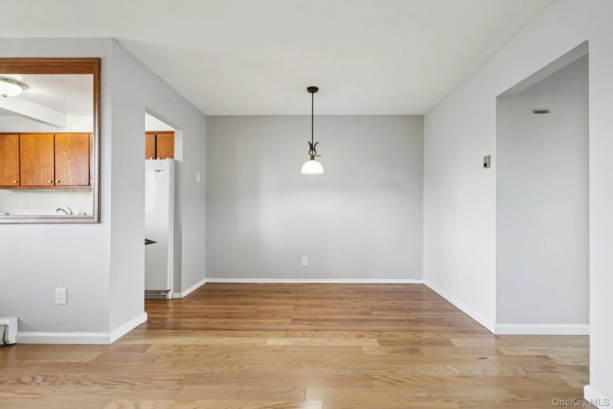 Unfurnished dining area featuring light wood-style floors and baseboard heating Unfurnished dining area featuring light wood-style floors and baseboard heating