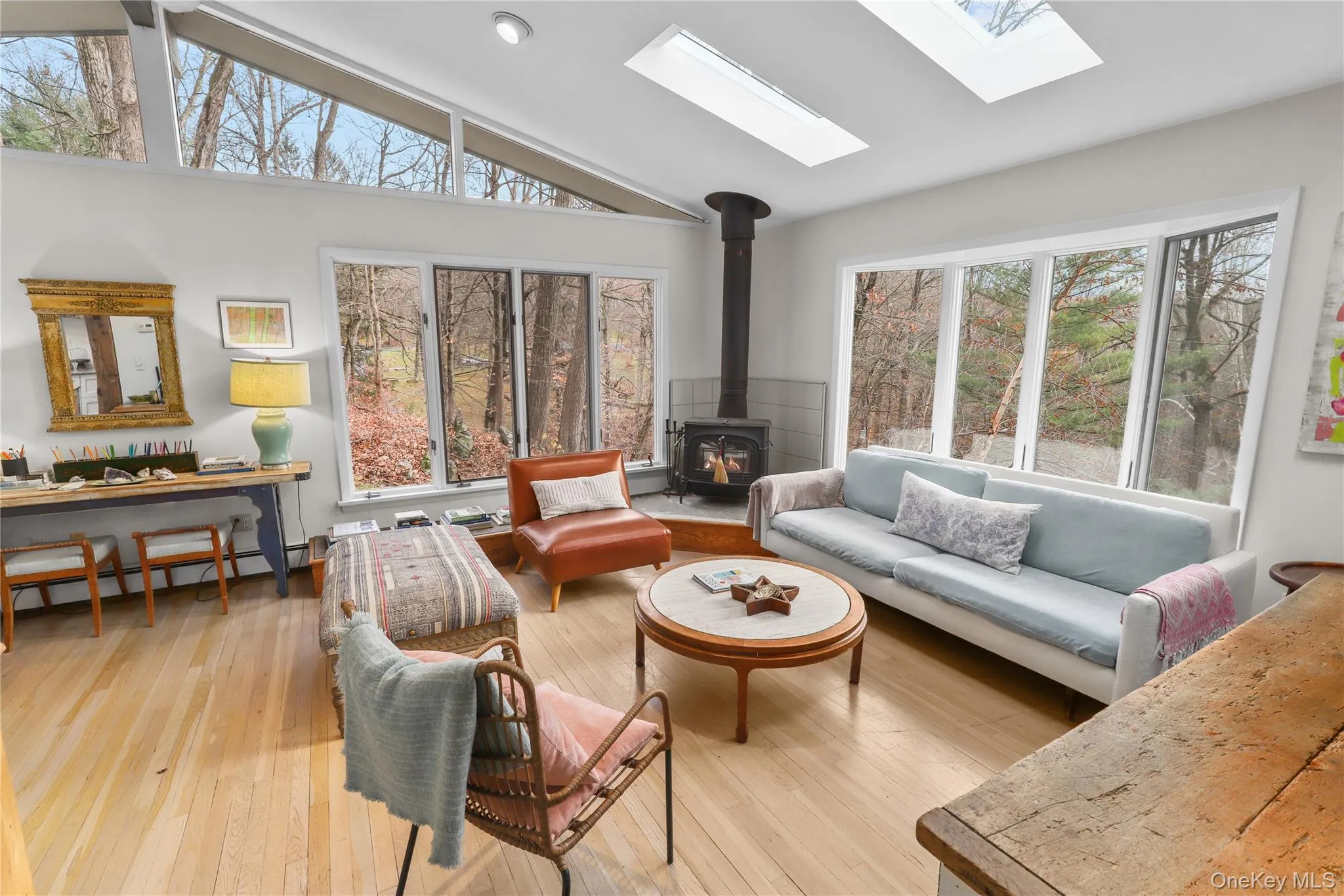 Sun-filled living room with bay windows and wood stove Sun-filled living room with bay windows and wood stove