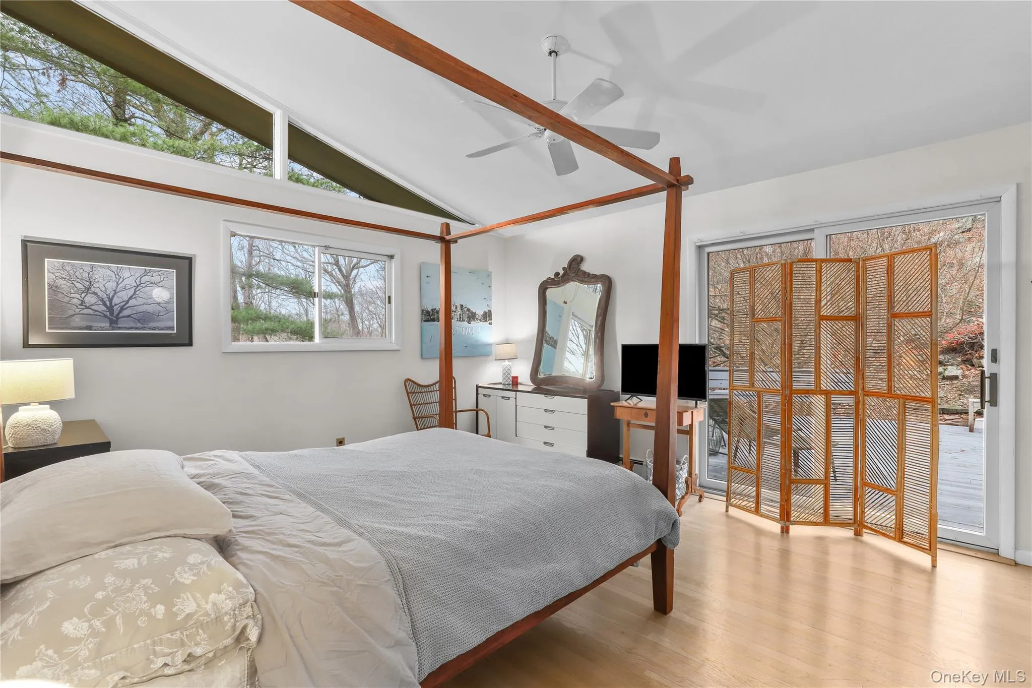 Bedroom featuring wood finished floors, a ceiling fan, and high vaulted ceiling Bedroom featuring wood finished floors, a ceiling fan, and high vaulted ceiling