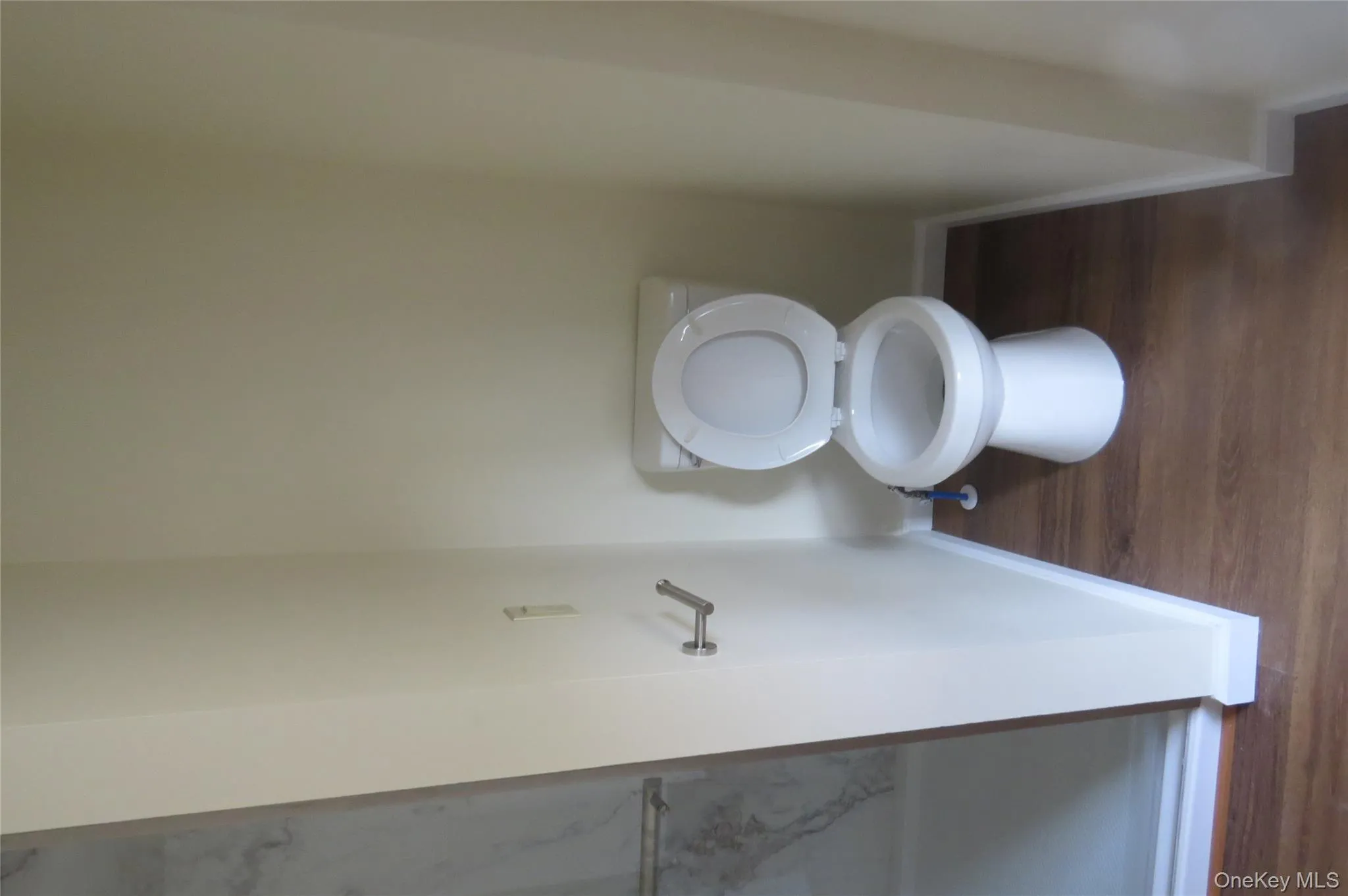 Bathroom featuring toilet, baseboards, and wood finished floors Bathroom featuring toilet, baseboards, and wood finished floors