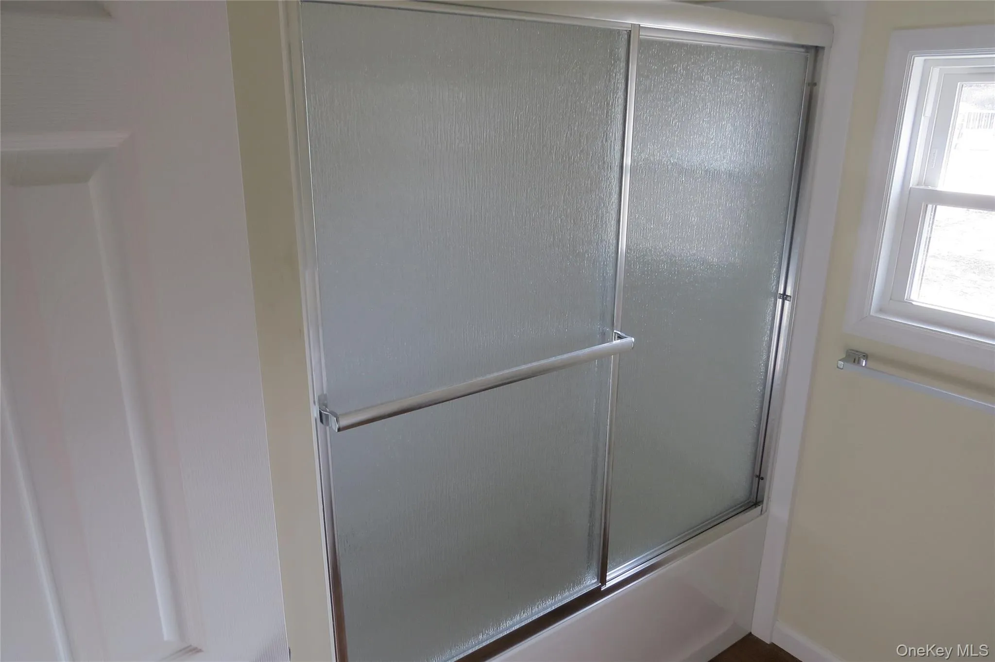 Bathroom with combined bath / shower with glass door Bathroom with combined bath / shower with glass door