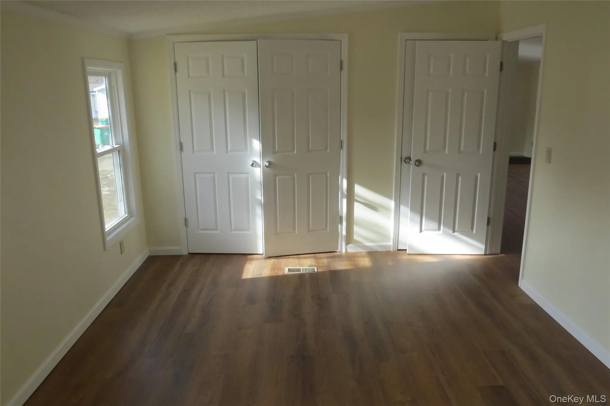 Unfurnished bedroom featuring a closet, wood finished floors, visible vents, and baseboards Unfurnished bedroom featuring a closet, wood finished floors, visible vents, and baseboards