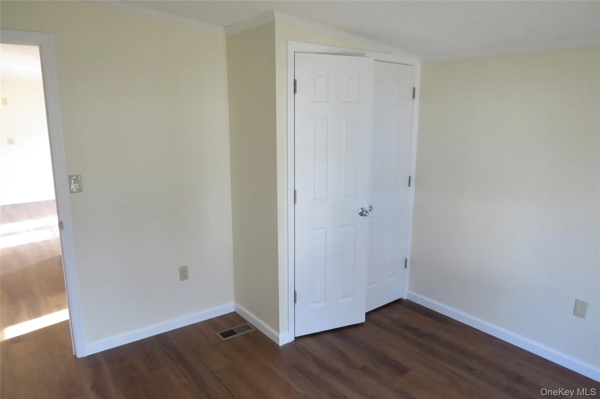 Unfurnished bedroom featuring dark wood-type flooring, a closet, visible vents, and baseboards Unfurnished bedroom featuring dark wood-type flooring, a closet, visible vents, and baseboards